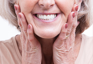 A woman smiling after receiving dentures at Singing River Dentistry in Florence, AL