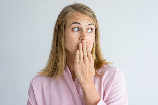 Woman holding her hand over her mouth due to her funky breath