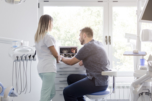 dental staff in office in front of monitors discuss customized treatment plans