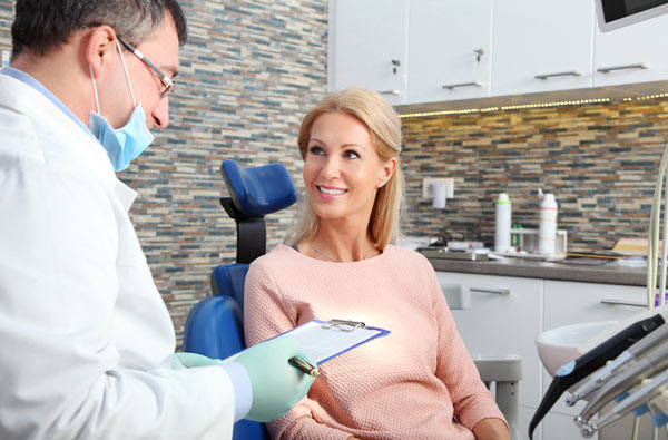 Woman talking to her dentist before getting a dental cleaning at Florence, AL