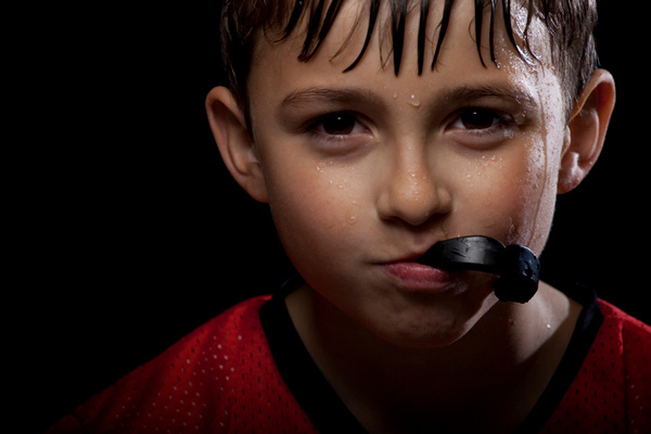 Sweaty boy with mouth guard in his mouth.