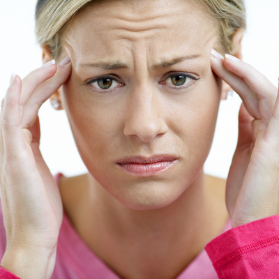 woman having a headache and holding her hands up to her temples